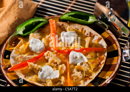 Fresh tortilla di farina ricoperte con il formaggio Cheddar, bocconcini di pollo e peperoni rossi dolci. Foto Stock