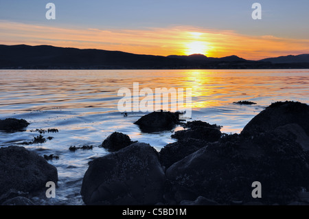 Il sole tramonta su Dunoon, catturato da tutto il Firth of Clyde a Gourock. Foto Stock