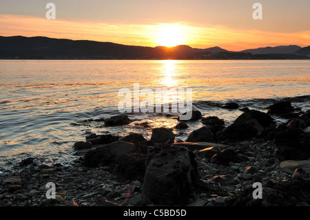 Il sole tramonta su Dunoon, catturato da tutto il Firth of Clyde a Gourock. Foto Stock