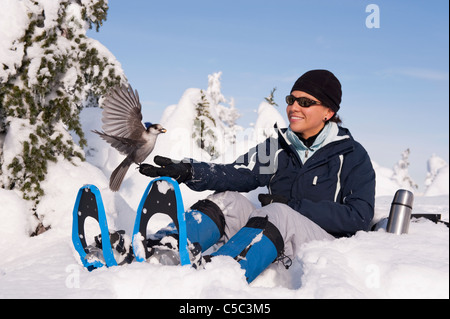 Bird si appollaia su donna ispanica la mano Foto Stock