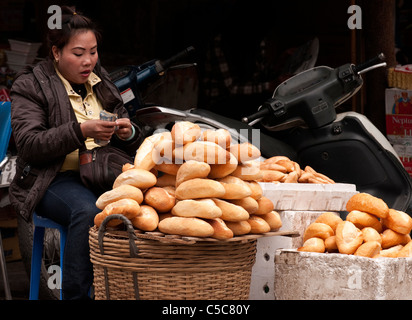 Donna baguette di vendita all'intersezione di Hang Chieu St e Hang Giay St, Hanoi Old Quarter, Vietnam Foto Stock