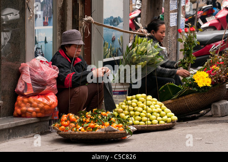 Venditori ambulanti che vendono frutta e fiori, Hang Bac St, Hanoi Old Quarter, Vietnam Foto Stock