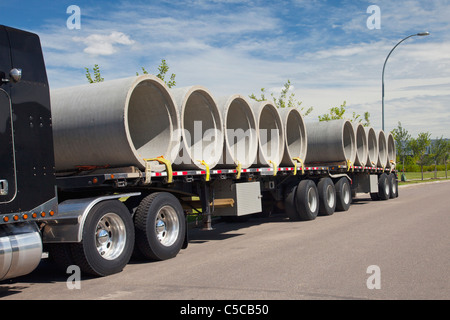 Semi-rimorchio camion che trasportano tubi fognari; Edmonton, Alberta, Canada Foto Stock