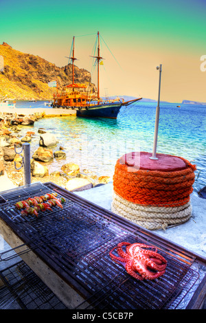 Polpo alla griglia e spiedini di gamberi sul barbecue a Santorini Grecia la cottura vicino al mare caldera cicladi Foto Stock