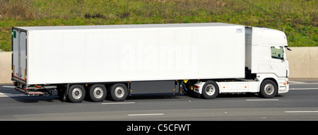 Attività di trasporto vista laterale del tutto bianco lungo camuffati pulito grande hgv autocarro autocarro e rimorchio articolato percorrendo l autostrada M25, England Regno Unito Foto Stock