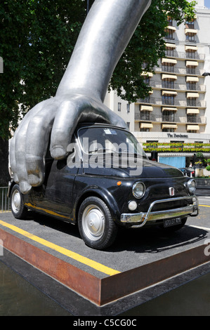 Mano sul Vintage Fiat Auto in arte moderna scultura "Vroom Vroom" dell'artista italiano Lorenzo Quinn fuori Dorchester Hotel di Mayfair London REGNO UNITO Foto Stock