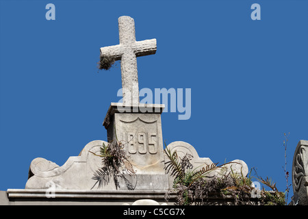 Tomba antica croce di pietra contro un cielo blu Foto Stock