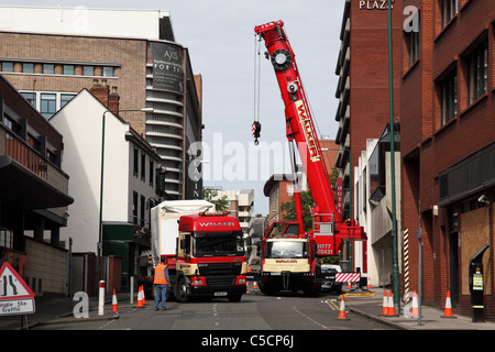 Una gru mobile lo scarico di un camion su una strada a Nottingham, Inghilterra, Regno Unito Foto Stock