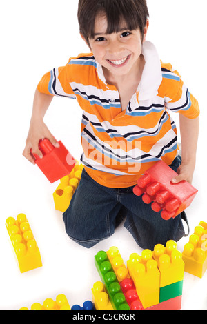 Giovane ragazzo giocando con la costruzione di blocchi su sfondo bianco Foto Stock