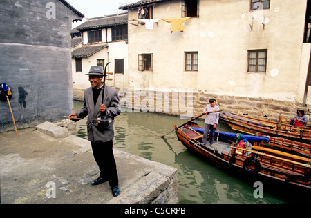 Qibao, Cina. Musicista cinese svolge il erhu, antico strumento cinese, per attrarre i turisti a prendere un giro in barca sul canale. Foto Stock