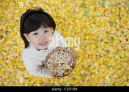 Ragazza con cestello che era pieno di gingko dadi Foto Stock