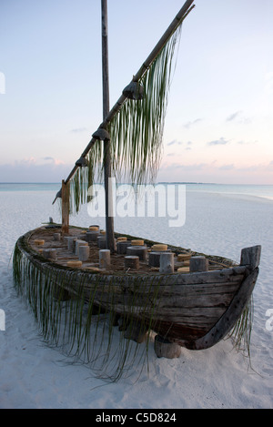Un vecchio congelata dhoni barca da pesca si trova in alto come decorazione sulla spiaggia. Coco Palm Dhuni Kolhu. La BAA Atol, Maldive. Foto Stock