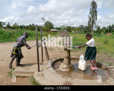 In Uganda i bambini raccolta di acqua dalla mano-foro pompato bene, Gulu. Foto di Sean Sprague Foto Stock