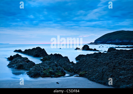 Vista crepuscolo degli strati di rocce e del canale di Bristol prese al crepuscolo da Croyde Bay, North Devon, Inghilterra, Regno Unito Foto Stock