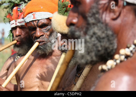 Tribal gli uomini che giocano i flauti di bambù in Papua Nuova Guinea Foto Stock