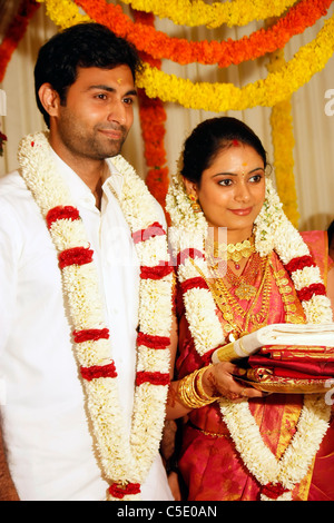 Sposa e lo sposo a piedi dopo la cerimonia del matrimonio in un Indiano nozze indù - tradizionale stile di medicazione Foto Stock