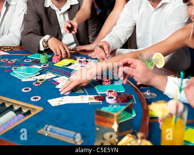 Mani sui giocatori di blackjack con cocktail e fiches del casinò Foto Stock