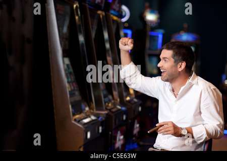 Bello il business man solo vincere alla slot machine Foto Stock