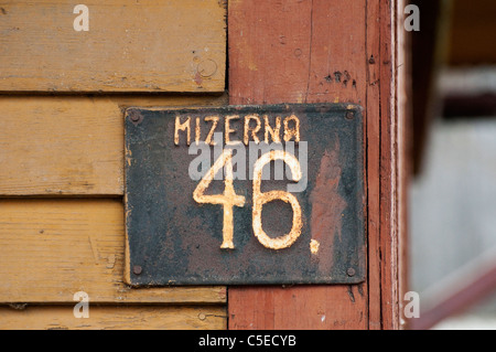 Numero di casa su una placca al di fuori di una casa del villaggio di Mizerna, Polonia. Foto Stock