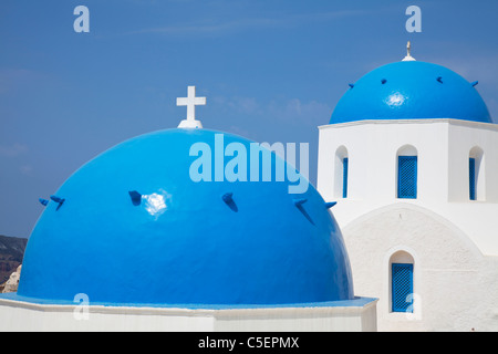 Oia - Santorini, isola greca, la Grecia, l'Europa. Iconica cupola blu, a cupola chiesa tipiche pareti dipinte di bianco e croce sulla parte superiore Foto Stock