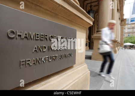 Business donna che abbandona la Camera di Commercio e Industria di Frankfurt am Main (segno) e la Borsa di Francoforte Francoforte, Germania Foto Stock