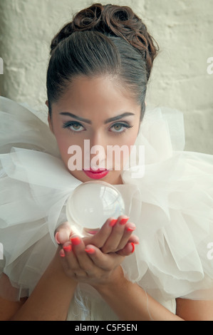 Donna che mantiene una sfera di cristallo Foto Stock