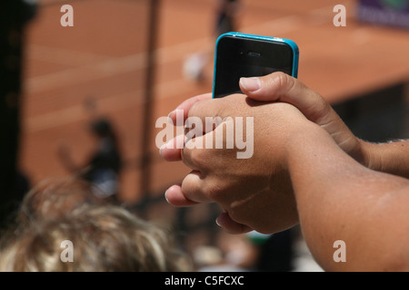 Dettaglio della donna tenendo iphone in Sun all'aperto Foto Stock