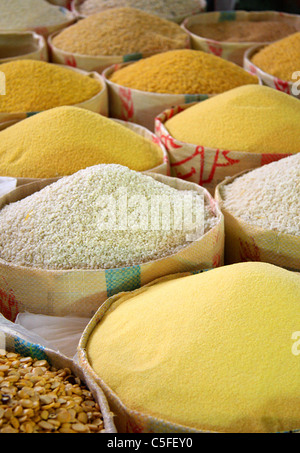 Grani, compreso il cous cous, presentata in sacchi per la vendita su una fase di stallo in un souk/mercato nella medina di Essaouira, Marocco, Africa Foto Stock