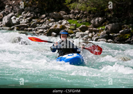 Femmina di whitewater kayaker riding classe III veloce sul fiume Inn vicino a Pfunds Austria Foto Stock