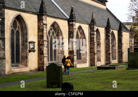 Una giovane coppia a piedi attraverso Greyfriars Kirk sagrato in autunno di Edimburgo, Scozia UK Foto Stock