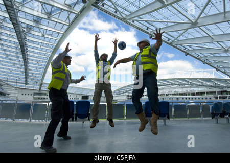 Tre costruttori di una partitella come lavoro si avvicina al completamento sulla nuova AMEX Stadium, casa di Brighton e Hove Albion dal 2011. Foto Stock