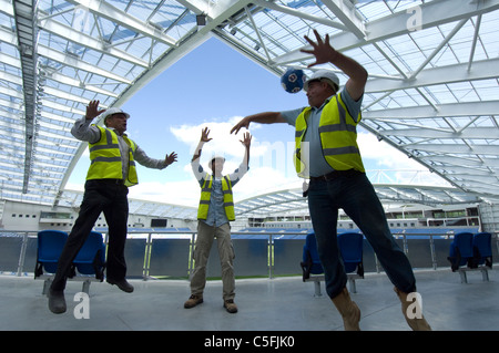 Tre costruttori di una partitella come lavoro si avvicina al completamento sulla nuova AMEX Stadium, casa di Brighton e Hove Albion dal 2011. Foto Stock
