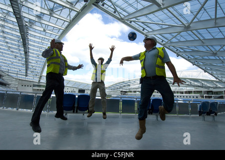 Tre costruttori di una partitella come lavoro si avvicina al completamento sulla nuova AMEX Stadium, casa di Brighton e Hove Albion dal 2011. Foto Stock