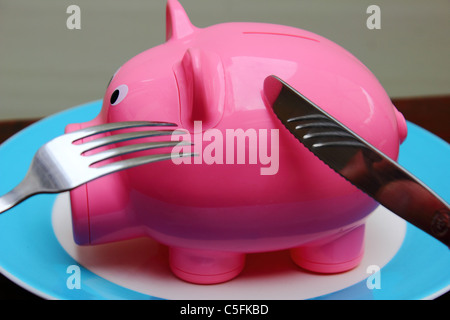 Un salvadanaio su di un piatto pronto a stato mangiato, immagine concettuale Foto Stock