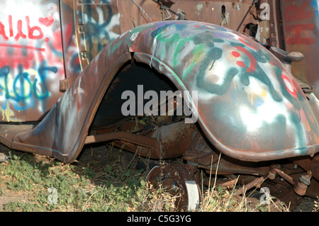 Il parafango di un 1933 Ford Coupe è un bersaglio per atti di vandalismo da parte di persone che pilotano il passato. La vettura si trova lungo la route 66 vicino a Amarillo. Foto Stock