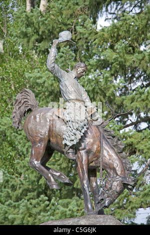 Una scultura in bronzo di un cowboy a cavallo di un strappi bronco nel centro della città di Jackson Hole, Wyoming negli Stati Uniti. Foto Stock