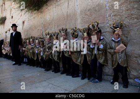 Ultra ortodosso bambini indossare la Torah e corone durante la celebrazione della festa ebraica di Shavuot che segna il dono della Torah a Mt. Il Sinai, sette settimane dopo l'esodo del popolo ebraico dall'Egitto. Parete occidentale della città vecchia di Gerusalemme Israele Foto Stock