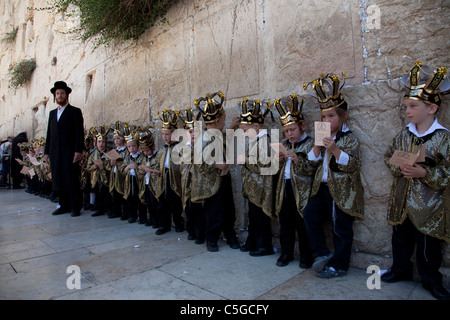 Ultra ortodosso bambini indossare la Torah e corone durante la celebrazione della festa ebraica di Shavuot che segna il dono della Torah a Mt. Il Sinai, sette settimane dopo l'esodo del popolo ebraico dall'Egitto. Parete occidentale della città vecchia di Gerusalemme Israele Foto Stock