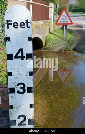 Indicatore di profondità che mostra il livello di acqua in un villaggio ford Foto Stock