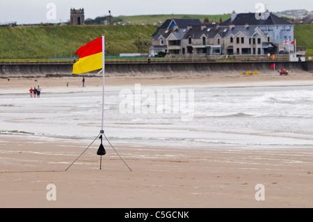 Rosso/giallo bandiera su una spiaggia che indica l'area sorvegliata da bagnino di salvataggio Foto Stock