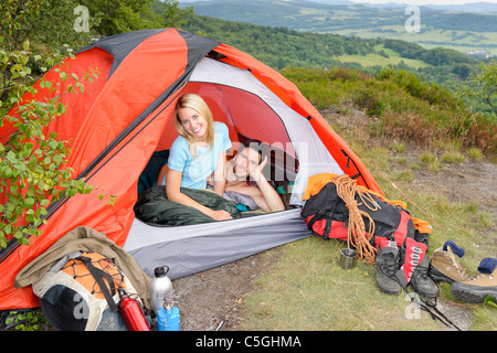 Camping coppia giovane backpackers in tenda con ingranaggio di arrampicata tramonto Foto Stock