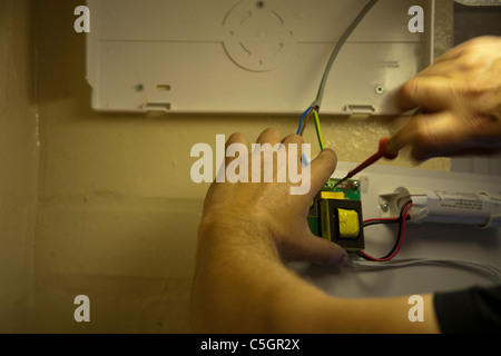 Elettricista qualificato installazione di illuminazione di emergenza Foto Stock