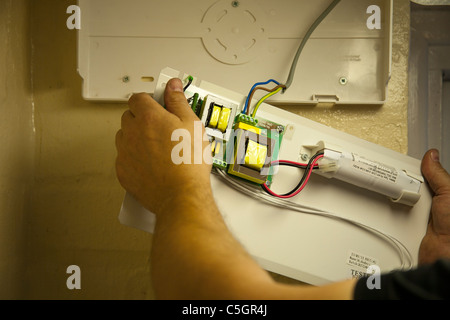 Elettricista qualificato l'installazione di luci di emergenza Foto Stock