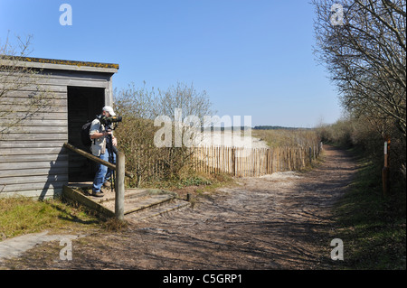 Osservazione degli uccelli con telescopio lasciando bird nascondere nella riserva naturale Parc du Marquenterre presso la Baia della Somme, Piccardia, Francia Foto Stock