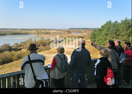 Guida con i turisti sulla piattaforma di osservazione che si affaccia su un terreno paludoso di riserva naturale Parc du Marquenterre, la baia della Somme, Francia Foto Stock