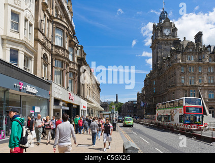 Negozi e shopperts in corrispondenza della estremità superiore di Princes Street con il Balmoral Hotel a destra, Edimburgo, Scozia, Regno Unito Foto Stock