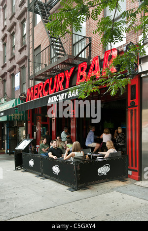 Patroni godendo bevande all'interno presso il bar & a tavoli esterni posti a sedere Bar mercurio in Hells Kitchen quartiere di New York City Foto Stock