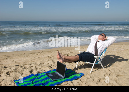 Un imprenditore prende il suo ufficio per la spiaggia. Foto Stock