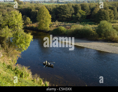Fiume Tweed e pescatore a mosca in barca a remi vicino Coldstream Foto Stock