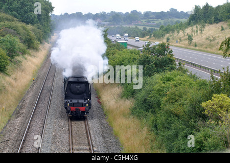 Treno a vapore sulla linea ferroviaria accanto all'autostrada M40, Warwickshire, Regno Unito Foto Stock